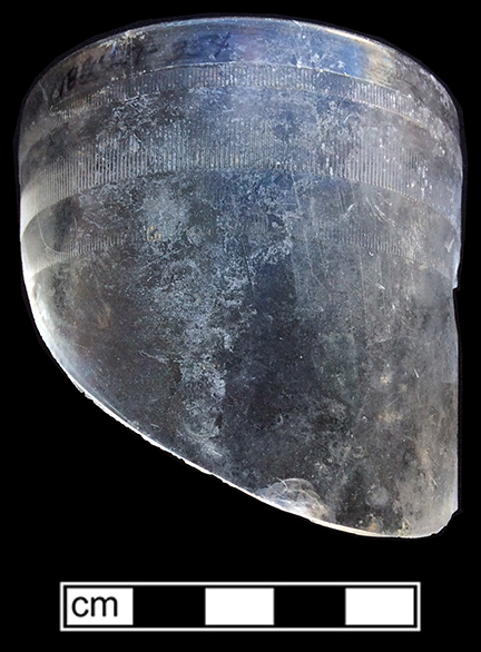 Tumbler (Packer’s Tumbler) of colorless soda lime glass. Three rows of fine vertical ridges near finish. Rim diameter:  2.75”; Lot 354. 18BC27-F38
